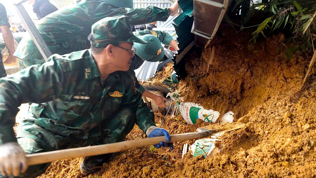 Những bì nông sản bị vùi lấp sâu dưới đất đá được các cán bộ chiến sĩ bới đất để đưa ra ngoài. Những bì nông sản bị vùi lấp sâu dưới đất đá được các cán bộ chiến sĩ bới đất để đưa ra ngoài.