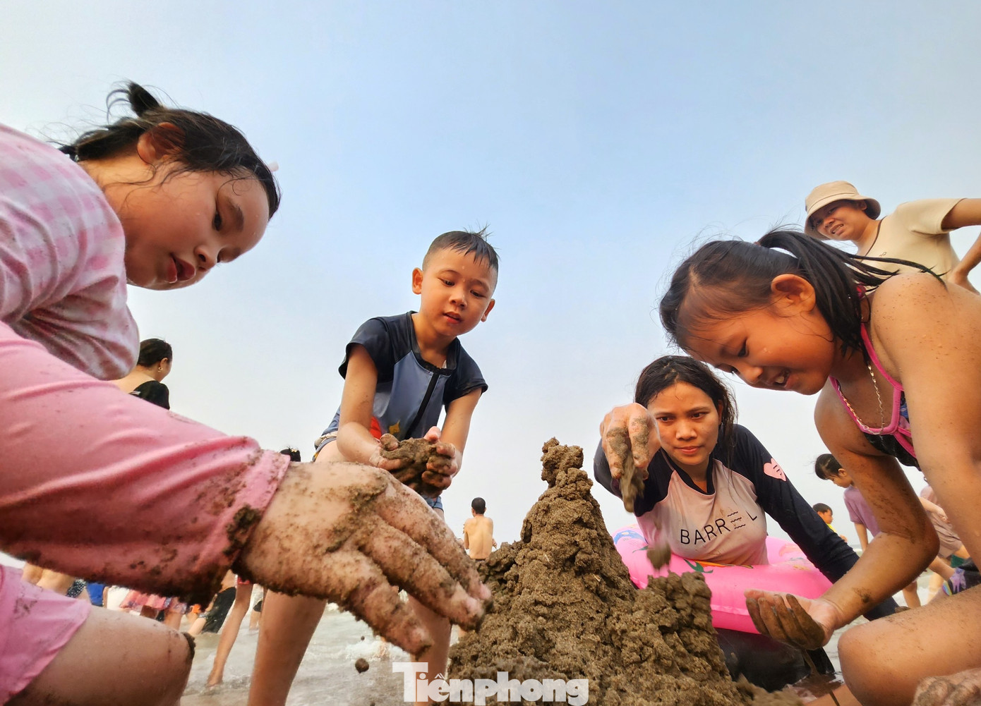 Nhiều em nhỏ vui sướng khi được ra biển và chơi đùa cùng cát.