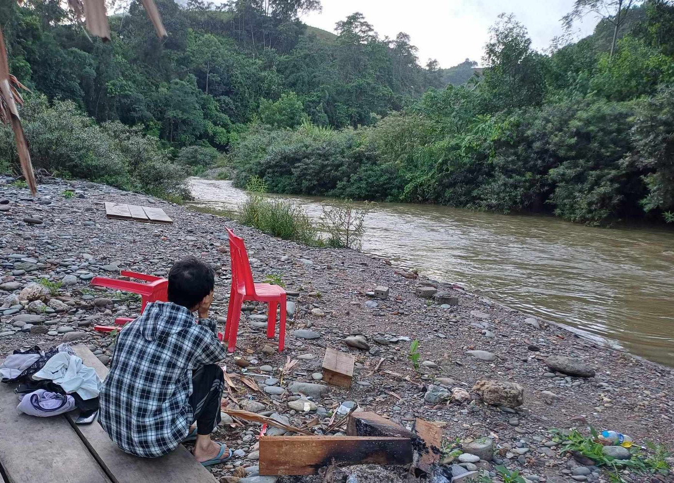 Người thân nam sinh ngồi ngóng đợi tin tức bên dòng suối. Người thân nam sinh ngồi ngóng đợi tin tức bên dòng suối.