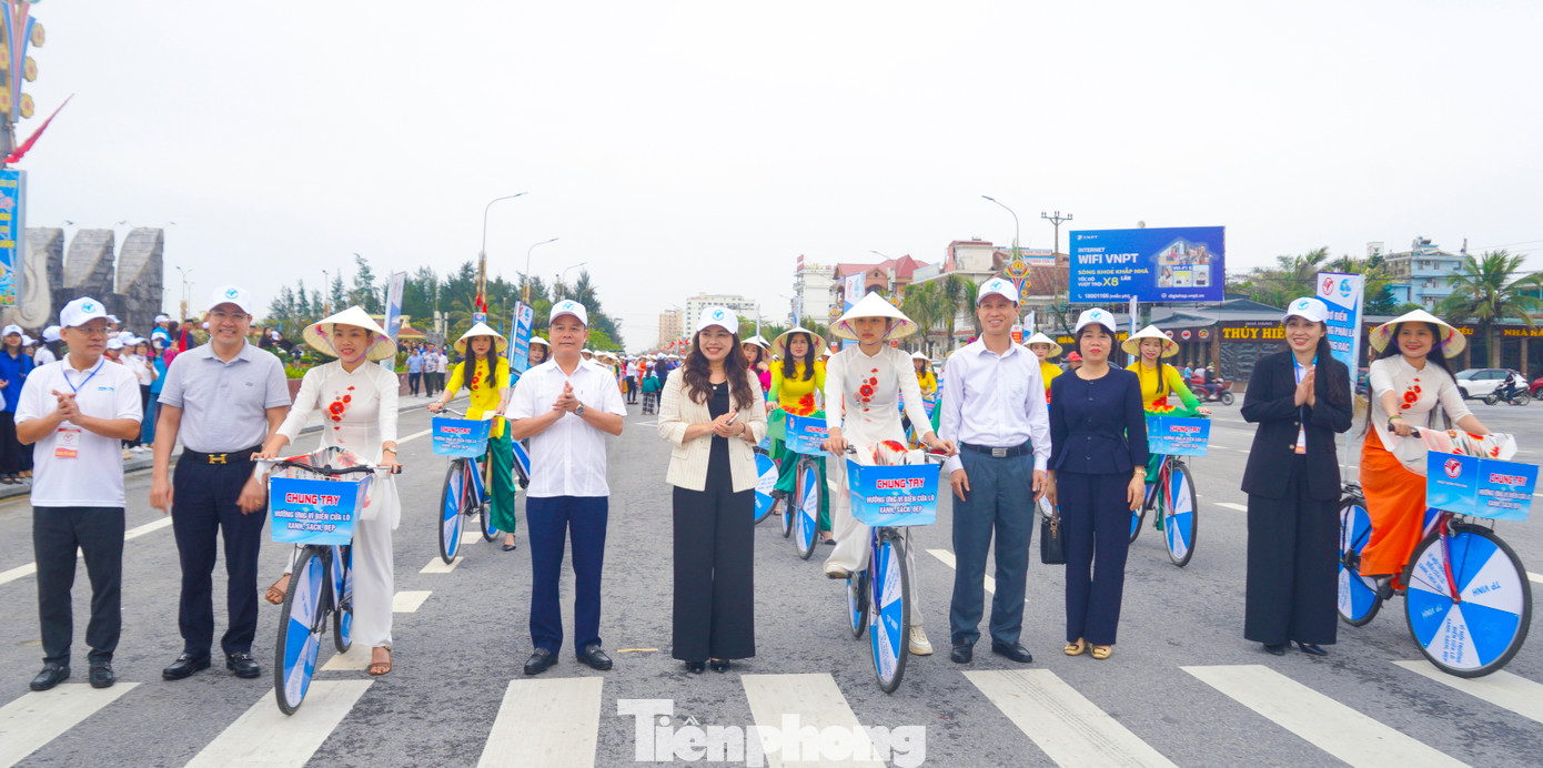 Các đại biểu hưởng ứng màn trình diễn áo dài Hoa cúc biển bằng hình thức diễu hành xe đạp.