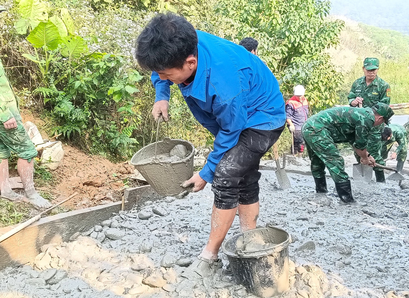 Do đường dốc núi nên việc đổ bê tông đều được các đoàn viên thanh niên thực hiện thủ công. Do đường dốc núi nên việc đổ bê tông đều được các đoàn viên thanh niên thực hiện thủ công.