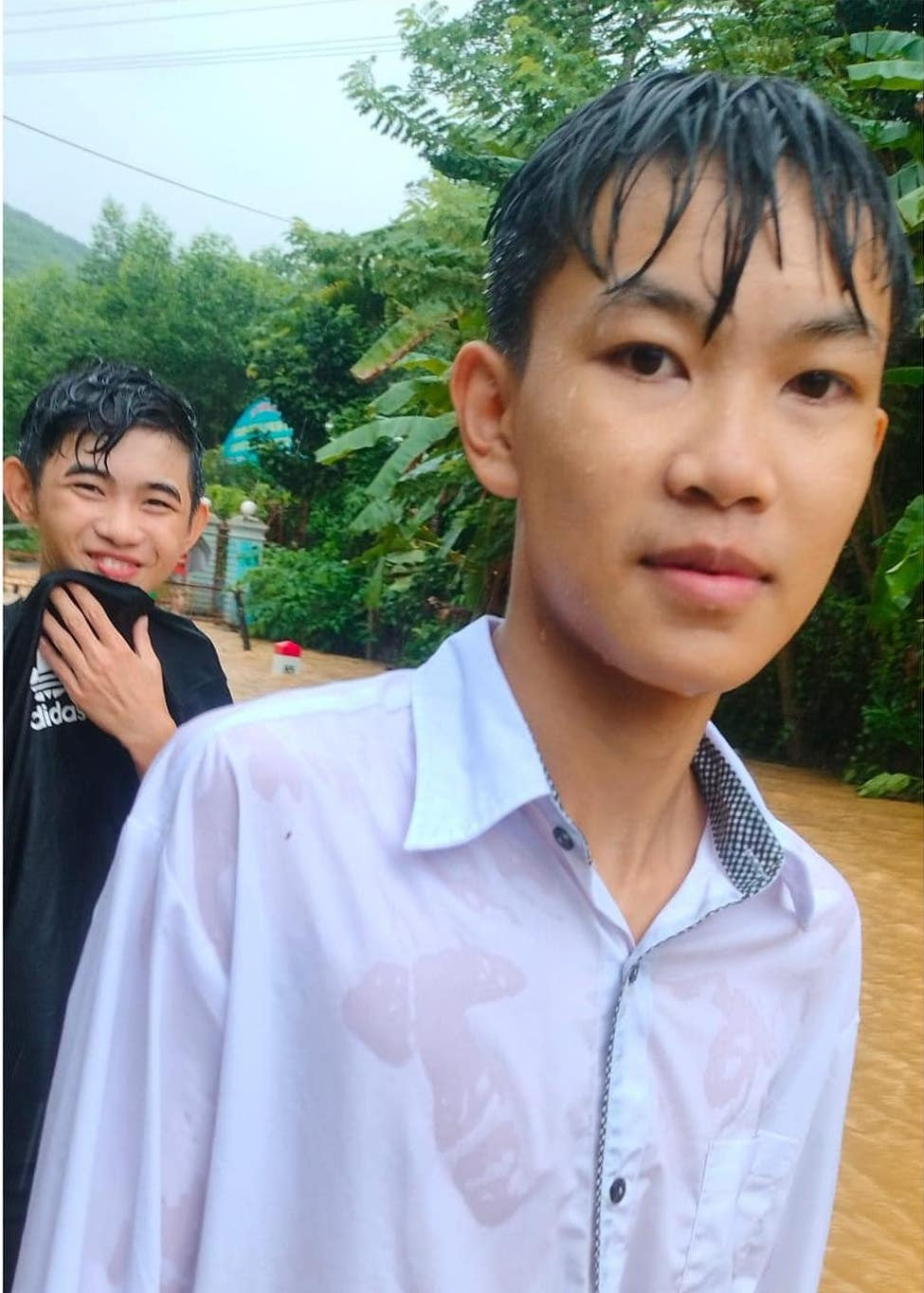 Các nam sinh thời điểm dầm mưa để cứu, giúp người trong mưa lũ.