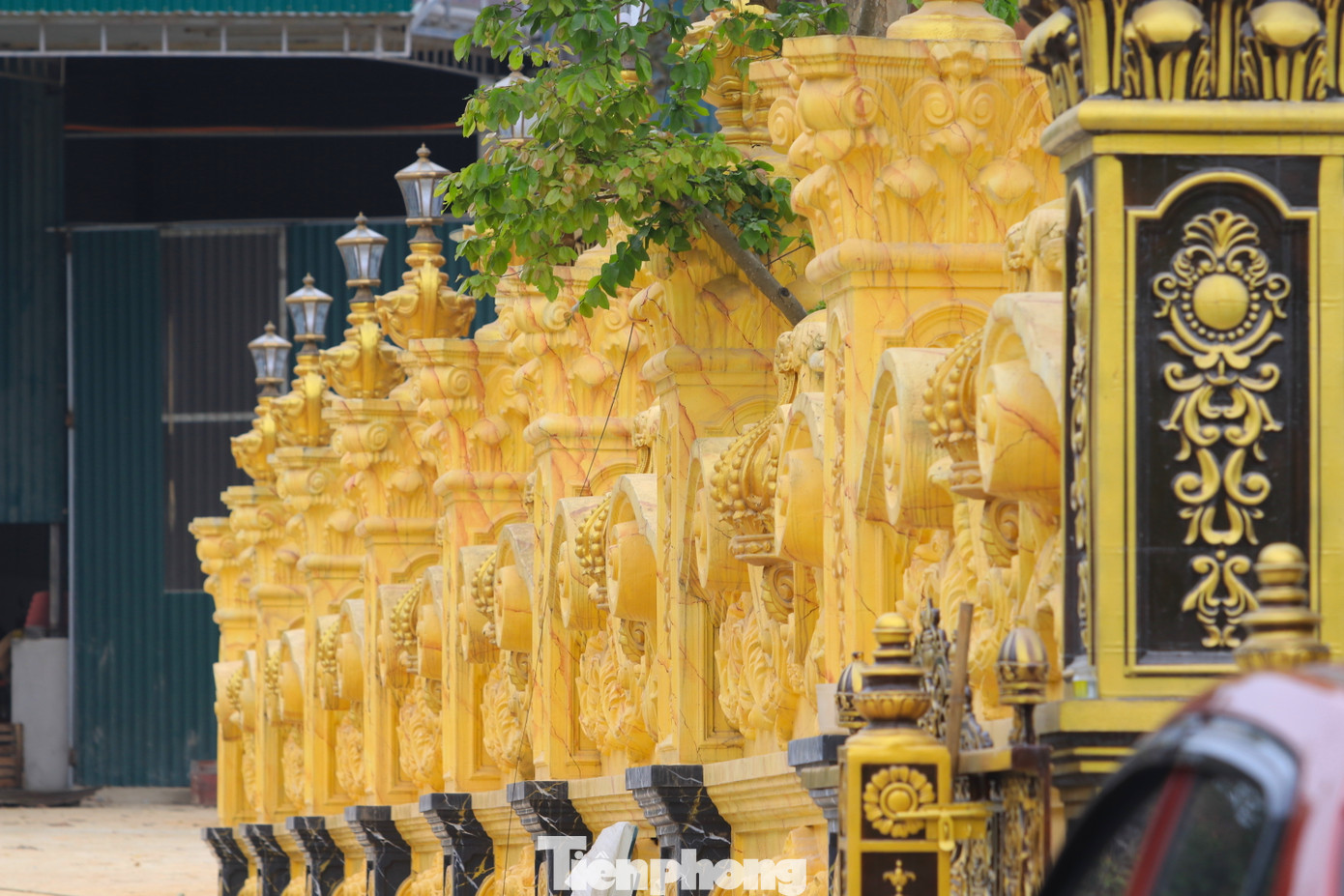 Ngoài cổng chính, chủ nhân thiết kế bảng tên phía trước trung tâm với dãy hàng rào được làm màu đồng vàng. Dãy tường rào sát tòa lâu đài được xây sơn đá màu vàng sang trọng.