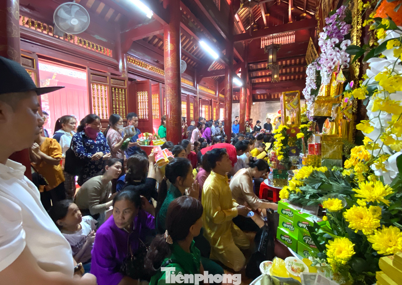 Bên trong khuôn viên đền chật kín người đứng, ngồi cúng bái.