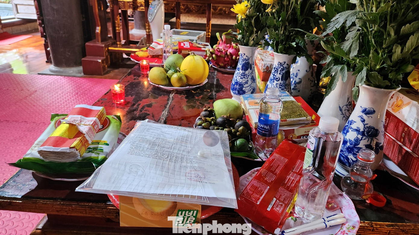 Trên bàn thờ, ngoài lễ vật hoa quả bánh kẹo, một số em học sinh còn để tập giấy báo dự thi, bút của mình.