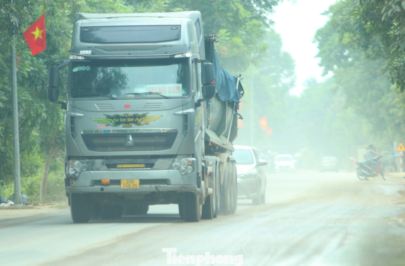 Cát rơi vãi dọc đường nên khi những chiếc xe chạy với tốc độ cao đi qua đã khiến bụi bay mù mịt.