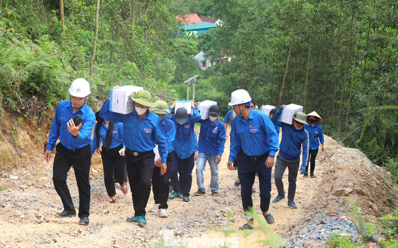 Các đoàn viên thanh niên vượt núi, vận chuyển nước lên tiếp sức cùng lực lượng thi công cột điện tại cột 309 qua xã Khánh Sơn (Nam Đàn, Nghệ An).
