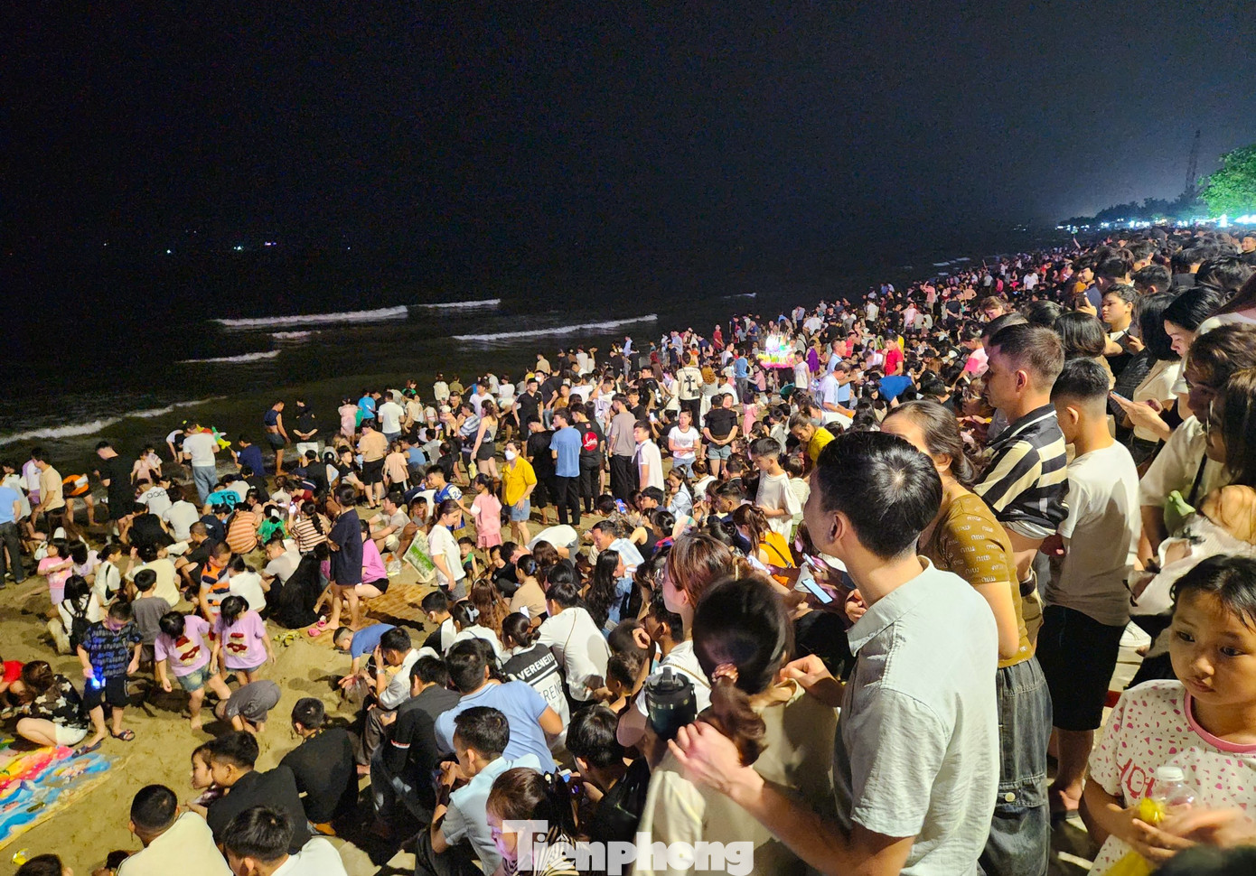 Phía ngoài bãi biển, du khách ngồi hóng mát và chờ đến màn bắn pháo hoa để được chiêm ngưỡng.