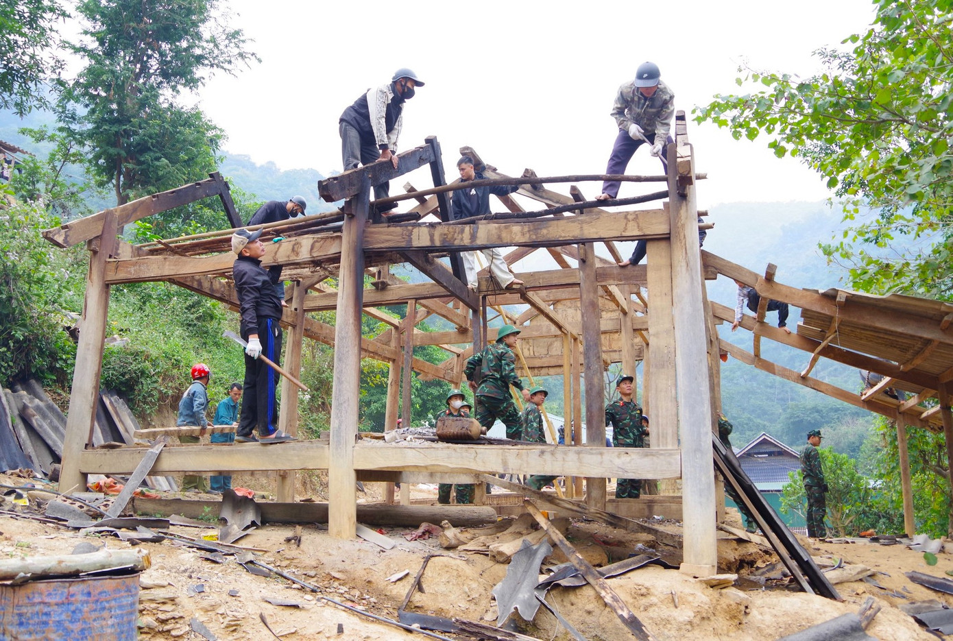 Các cán bộ chiến sĩ cẩn thận tháo dỡ nhà, vận chuyển tài sản ra ngoài. (Ảnh: Trọng Kiên Châu Khang).