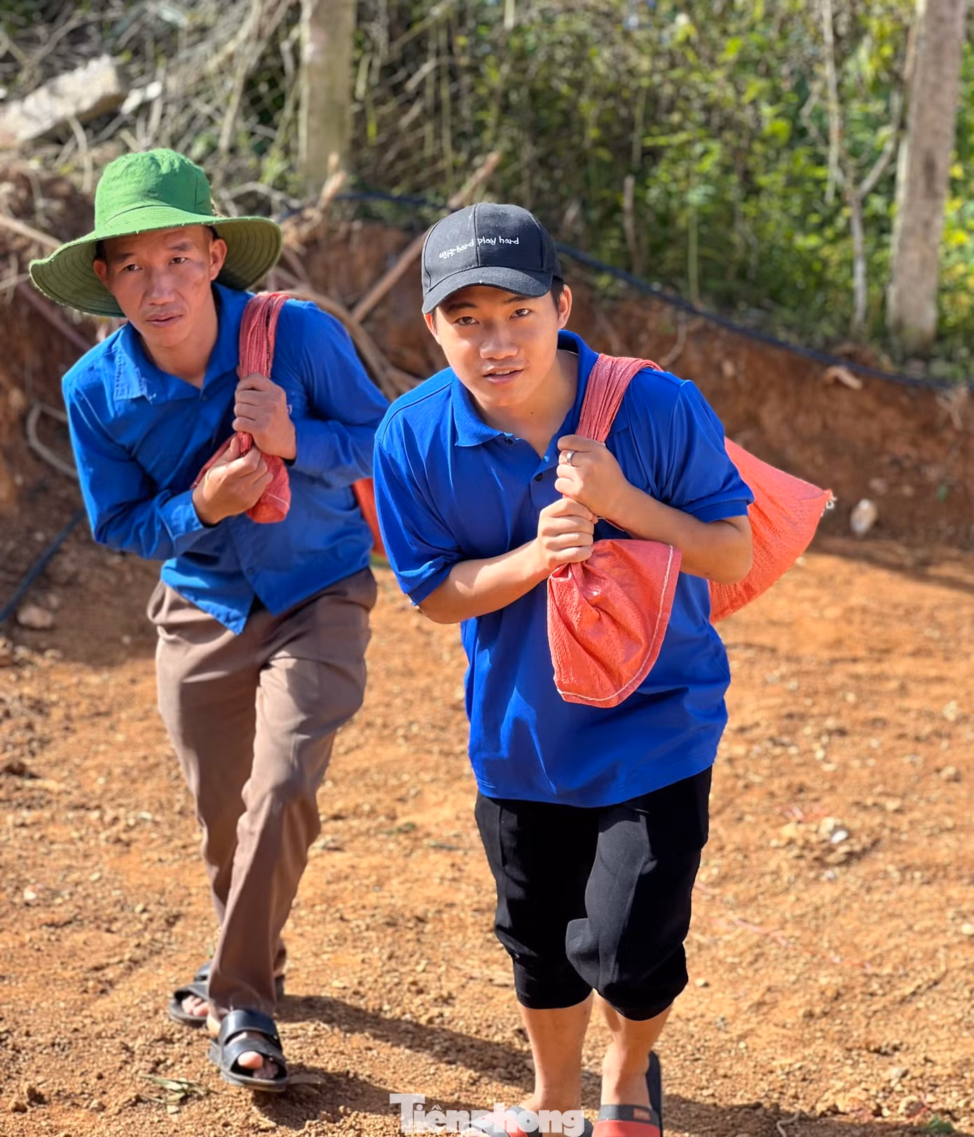Những nam thanh niên khỏe mạnh phụ trách cõng từng bì cát, đá lớn nặng cả chục kilogam.