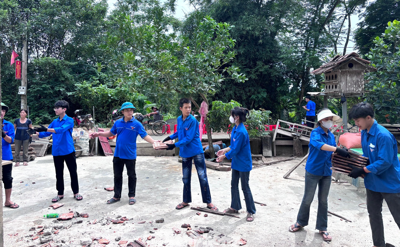 Đoàn viên thanh niên xếp thành hàng dài để tháo dỡ ngói từ mái nhà xuống cất cẩn thận, tránh bị hư hỏng. Đoàn viên thanh niên xếp thành hàng dài để tháo dỡ ngói từ mái nhà xuống cất cẩn thận, tránh bị hư hỏng.