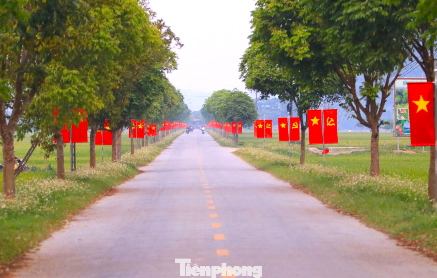 Tại huyện Con Cuông (Nghệ An), con đường dẫn vào trung tâm xã biên giới Môn Sơn đã được dọn sạch đẹp, trang trí cờ hoa rực rỡ từ nhiều ngày trước. Ảnh: Ngọc Tú.