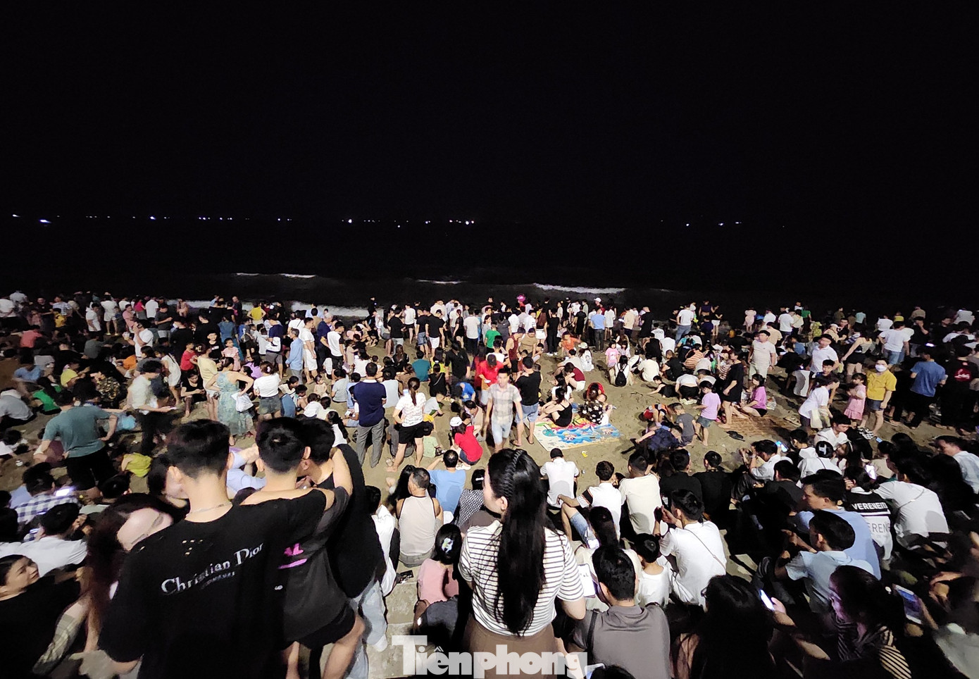 Phía ngoài bãi biển, du khách ngồi hóng mát và chờ đến màn bắn pháo hoa để được chiêm ngưỡng.