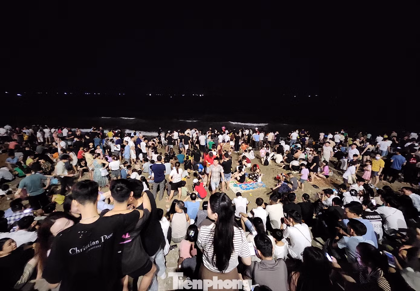 Phía ngoài bãi biển, du khách ngồi hóng mát và chờ đến màn bắn pháo hoa để được chiêm ngưỡng.