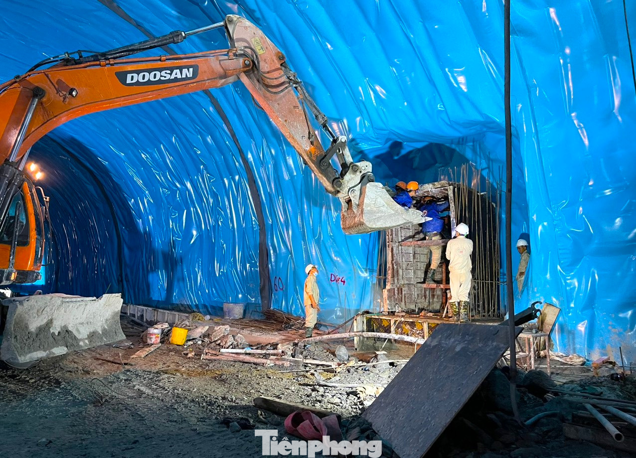 Các cán bộ, công nhân và máy móc miệt mài làm việc trong hầm Thần Vũ. Được biết, để động viên công nhân làm việc trong dịp Tết Nguyên đán, các công nhân Công ty Hòa Hiệp sẽ được tính 300% lương so với ngày thường.