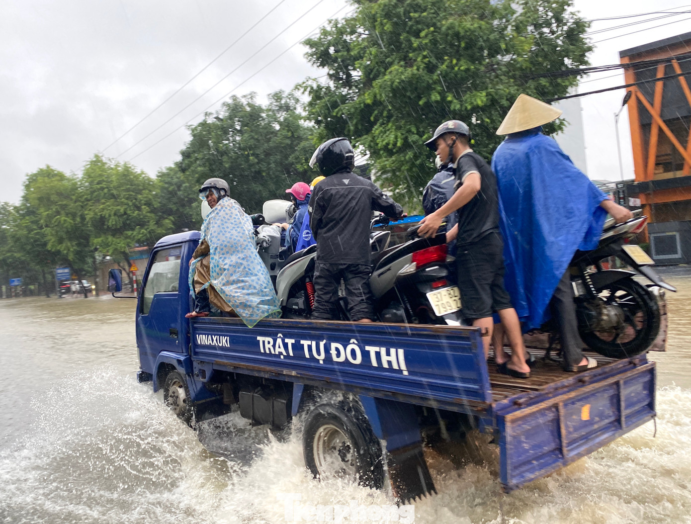 Một số xe máy may mắn được các cán bộ Trật tự đô thị thành phố Vinh "cứu trợ" đi qua đường ngập.