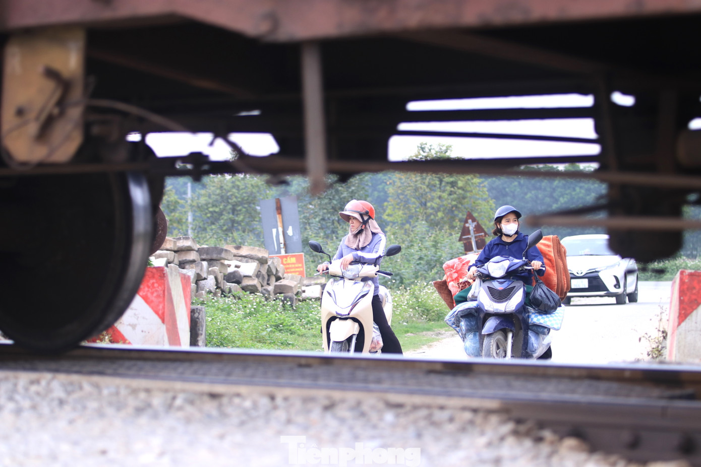 Người dân xã Hưng Mỹ đứng chờ đoàn tàu đi qua tại một lối mòn tự mở để rẽ vào đường ngang dân sinh.