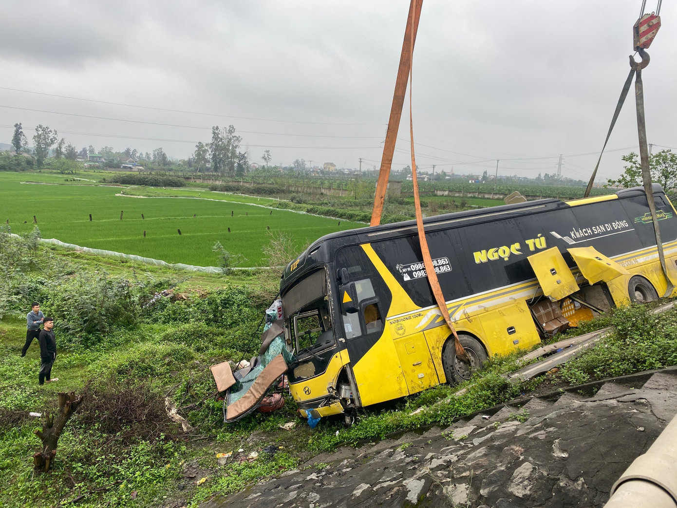 Chiếc xe khách bị hư hỏng nặng phần đầu và phía bên phải xe sau tai nạn. Nhiều hành lý rơi xuống ruộng bên đường. Chiếc xe khách bị hư hỏng nặng phần đầu và phía bên phải xe sau tai nạn. Nhiều hành lý rơi xuống ruộng bên đường.