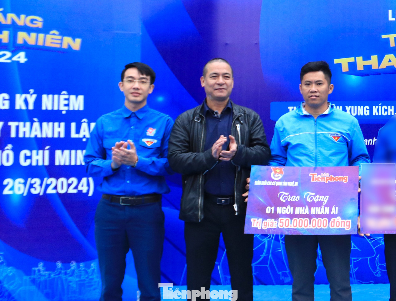 Nhà báo Trần Quang Long - Trưởng Văn phòng đại diện Báo Tiền Phong tại Bắc Trung Bộ và anh Nguyễn Công Minh - UVBTV Tỉnh Đoàn, Bí thư Đoàn Khối các cơ quan tỉnh trao biển tượng trưng ngôi nhà nhân ái trị giá 50 triệu đồng cho gia đình em Lương Khăm Phon.