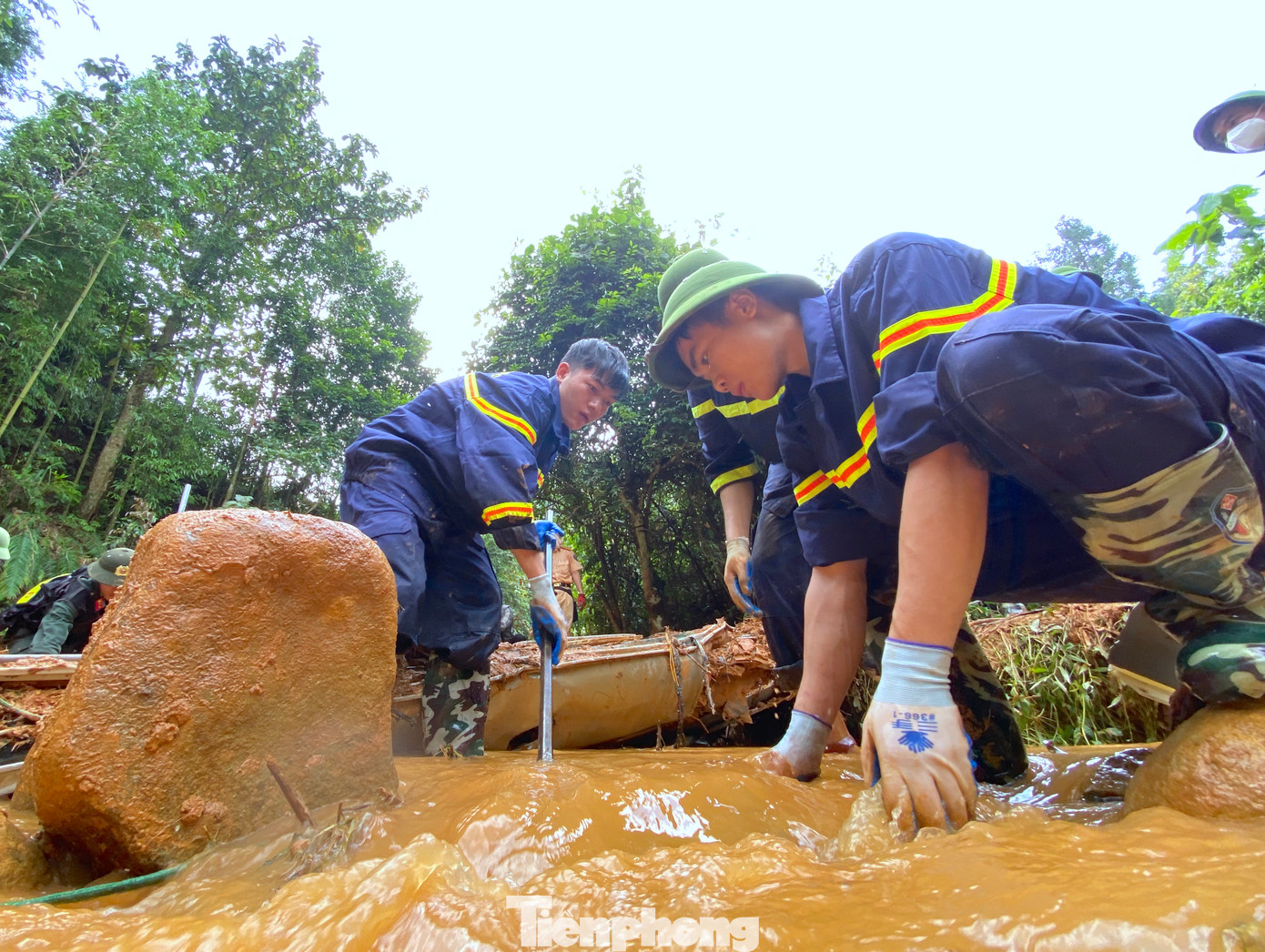 Các chiến sĩ cảnh sát PCCC&amp;CNCH Công an tỉnh Cao Bằng dùng xà beng cạy đất đá vùi lấp chiếc xe khách.