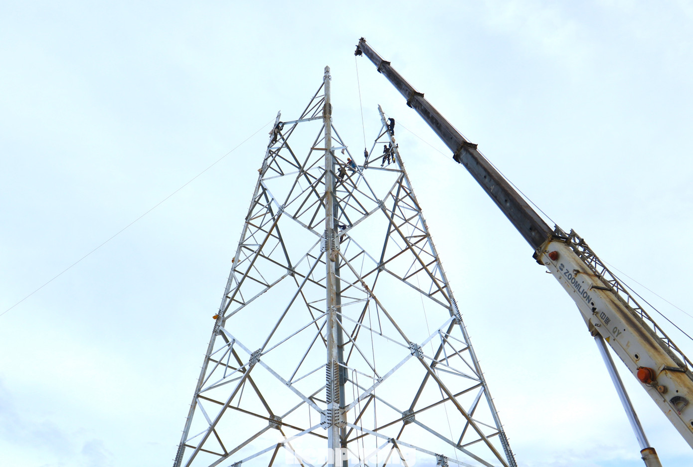"Cẩu lớn cũng chỉ hỗ trợ cẩu vật liệu và lắp ghép đến cánh xà đầu tiên của cột điện. Còn từ đó lên đến đỉnh phải dùng một chiếc tời rồi kéo lên cao và dùng sức người. Trời mát còn đỡ chứ nắng nóng làm việc vất vả lắm", ông Đặng Đình Toan (54 tuổi) - Đội trưởng đội xây dựng tại cột điện 356 xã Nghi Kiều (Nghi Lộc, Nghệ An) chia sẻ.