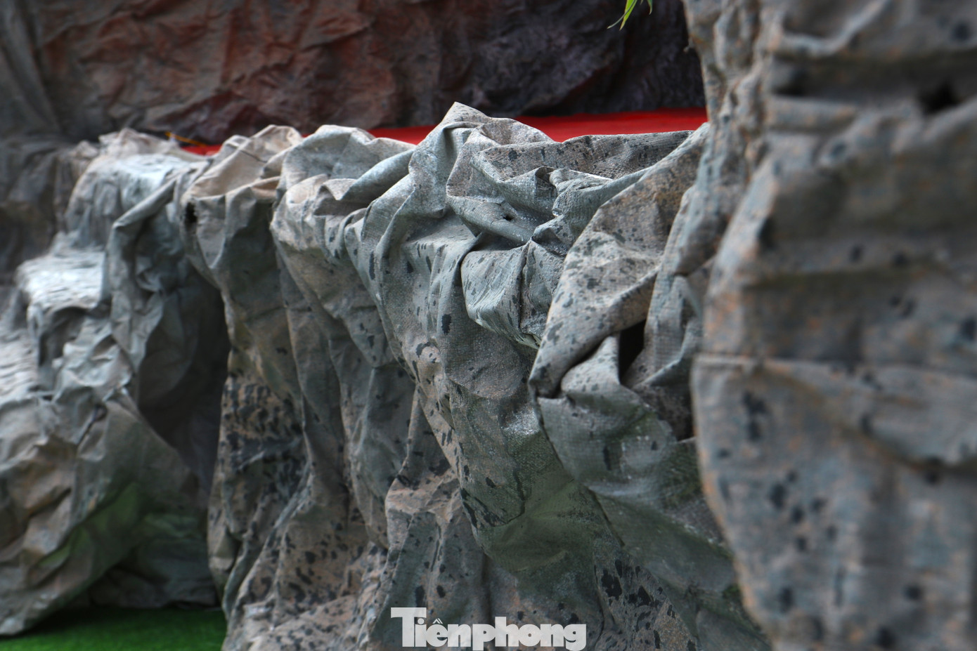 Những vỏ bao bì xi-măng sau khi làm sạch đã được người dân xử lý và tạo hình như những vách núi đá thực thụ. "Bao bì được làm sạch rồi phơi khô. Sau đó sẽ dùng lửa hơn để tạo nếp nhăn rồi bắn ghim lên như những hang, vách đá. Cuối cùng là sơn lót và sơn màu lên cho giống vách núi đá thật", ông Nguyễn Văn Nhiên nói và cho hay công đoạn thiết kế, tạo hình làm sao cho giống vách núi đá thật là công đoạn khó nhất trong làm hang đá này. Những vỏ bao bì xi-măng sau khi làm sạch đã được người dân xử lý và tạo hình như những vách núi đá thực thụ. "Bao bì được làm sạch rồi phơi khô. Sau đó sẽ dùng lửa hơn để tạo nếp nhăn rồi bắn ghim lên như những hang, vách đá. Cuối cùng là sơn lót và sơn màu lên cho giống vách núi đá thật", ông Nguyễn Văn Nhiên nói và cho hay công đoạn thiết kế, tạo hình làm sao cho giống vách núi đá thật là công đoạn khó nhất trong làm hang đá này.