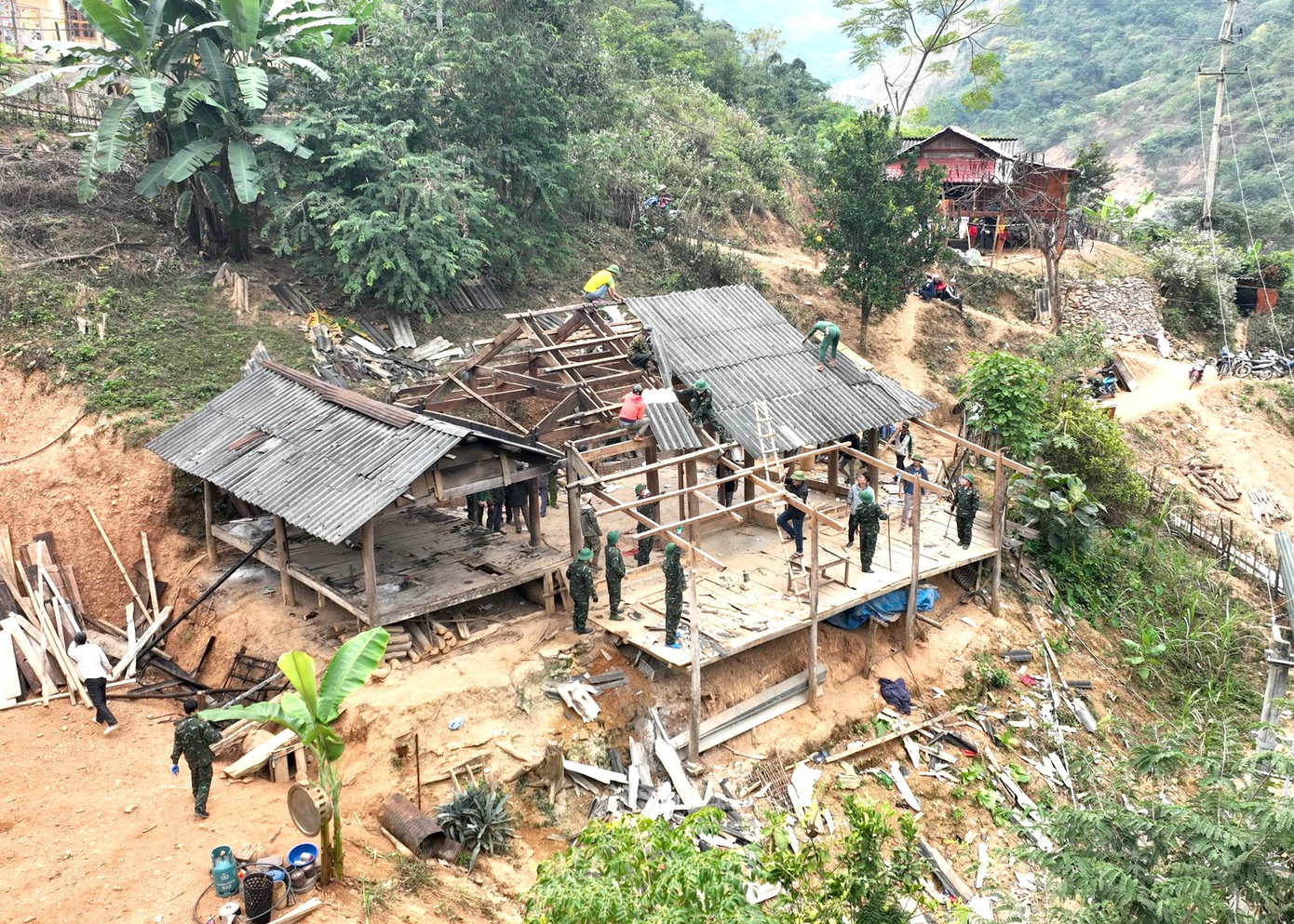 Những ngày cuối tháng 12, hàng chục cán bộ chiến sĩ Ban Chỉ huy Quân sự huyện Kỳ Sơn (Nghệ An) phối hợp cùng lực lượng Dân quân tự vệ huyện và chính quyền địa phương giúp đỡ người dân bản Vàng Phao (xã Mường Típ, huyện Kỳ Sơn) chuyển đến khu tái định cư mới. (Ảnh: Trọng Kiên Châu Khang).