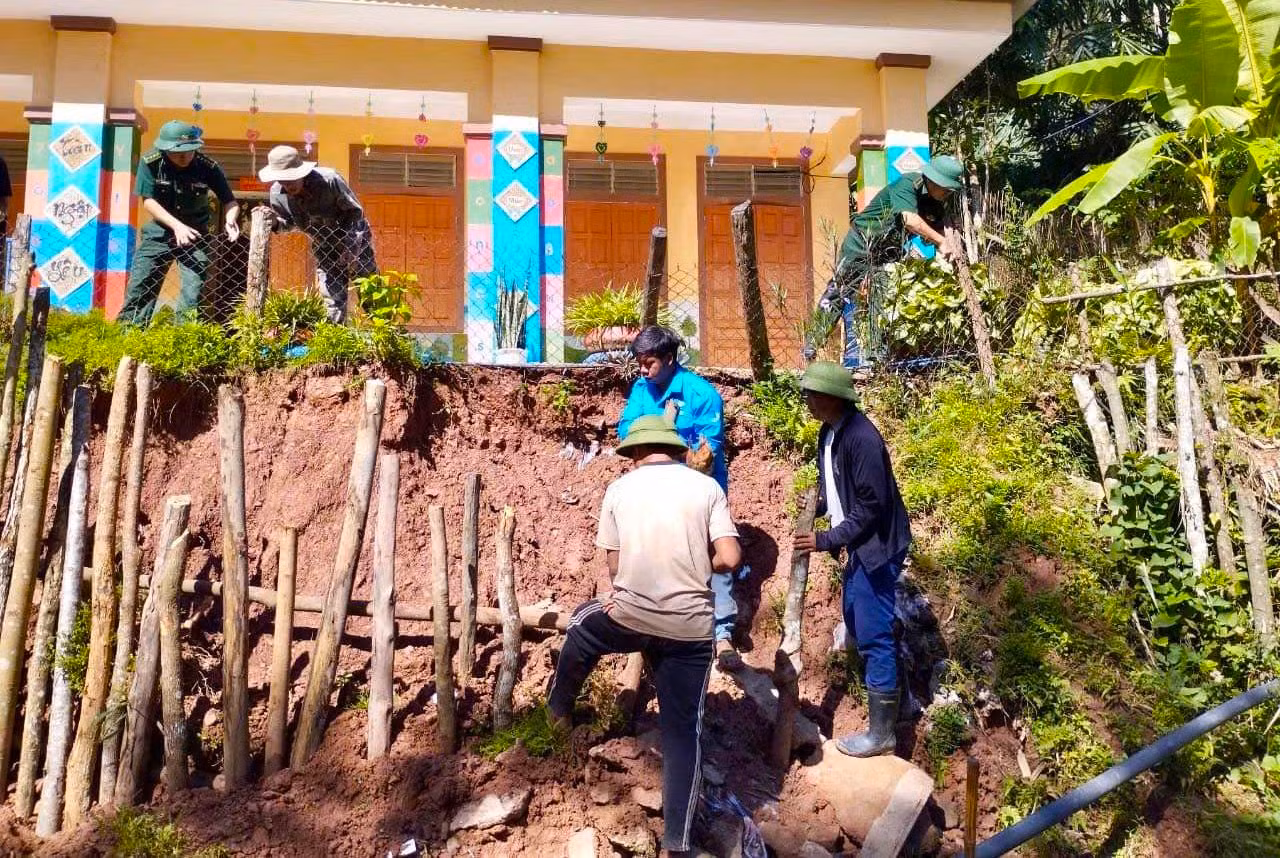 Người dân cùng cán bộ chiến sĩ Bộ đội Biên phòng và đoàn viên thanh niên vận chuyển đá kè lại khu vực trường mầm non Keng Đu bị sạt lở sau những trận mưa lớn.