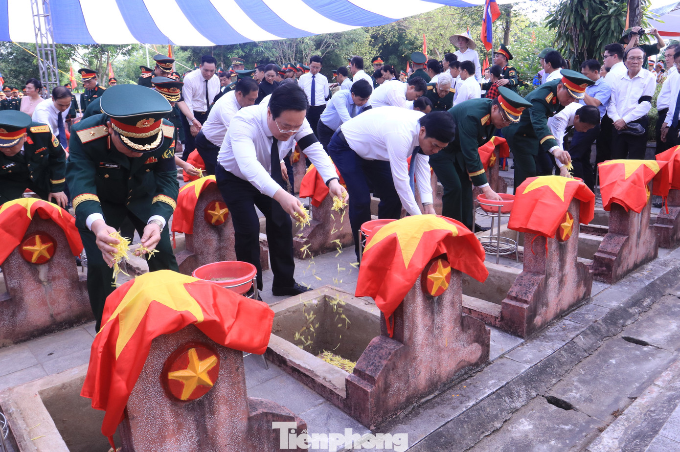 Các đại biểu rải hoa lên các phần mộ liệt sĩ trước khi thực hiện nghi lễ an táng.