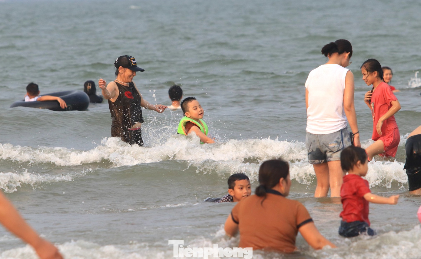 Dưới nước, du khách tắm mát và thích thú vui đùa cùng sóng biển. Dưới nước, du khách tắm mát và thích thú vui đùa cùng sóng biển.