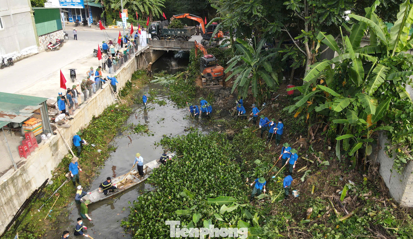 Đoàn viên thanh niên cùng các lực lượng chức năng xuống dòng khe để dọn rác, dọn bèo lục bình.