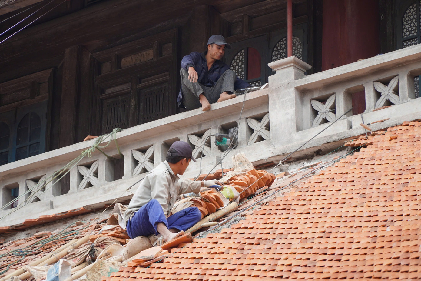 Những người thợ đang lợp lại những viên ngói mới. Ảnh: Đ.H. Những người thợ đang lợp lại những viên ngói mới. Ảnh: Đ.H.