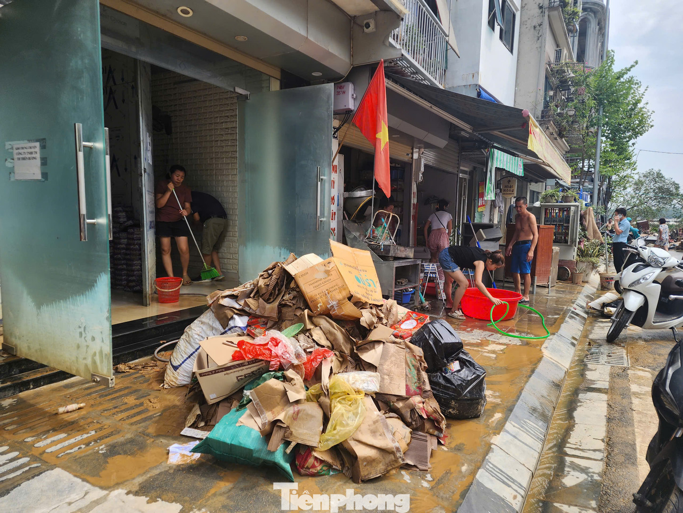 Tại đường Chương Dương Độ, người dân đưa đồ đạc ra ngoài để xịt rửa, quét bùn ra khỏi nhà.