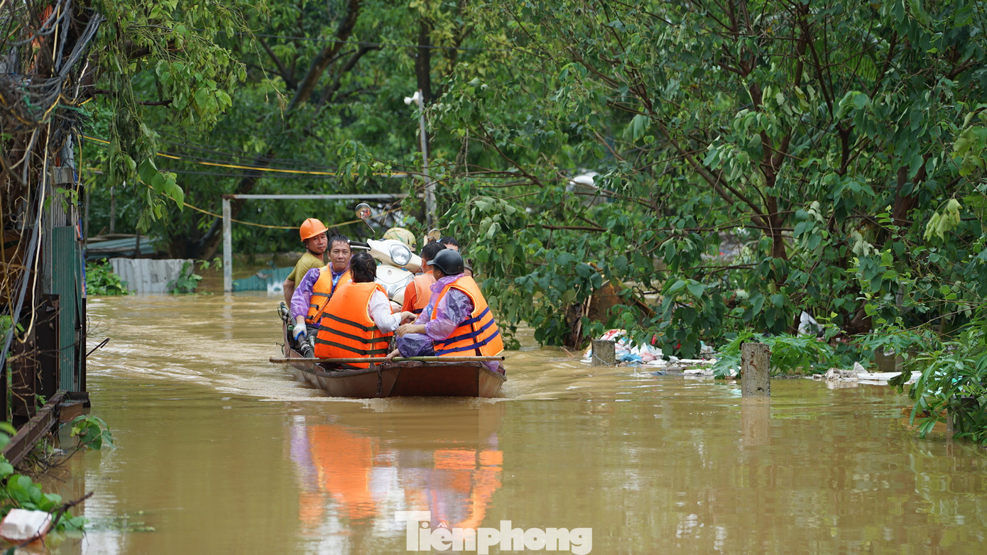 Thuyền máy chở phương tiện ra khỏi khu vực ngập sâu trong bãi bồi sông Hồng