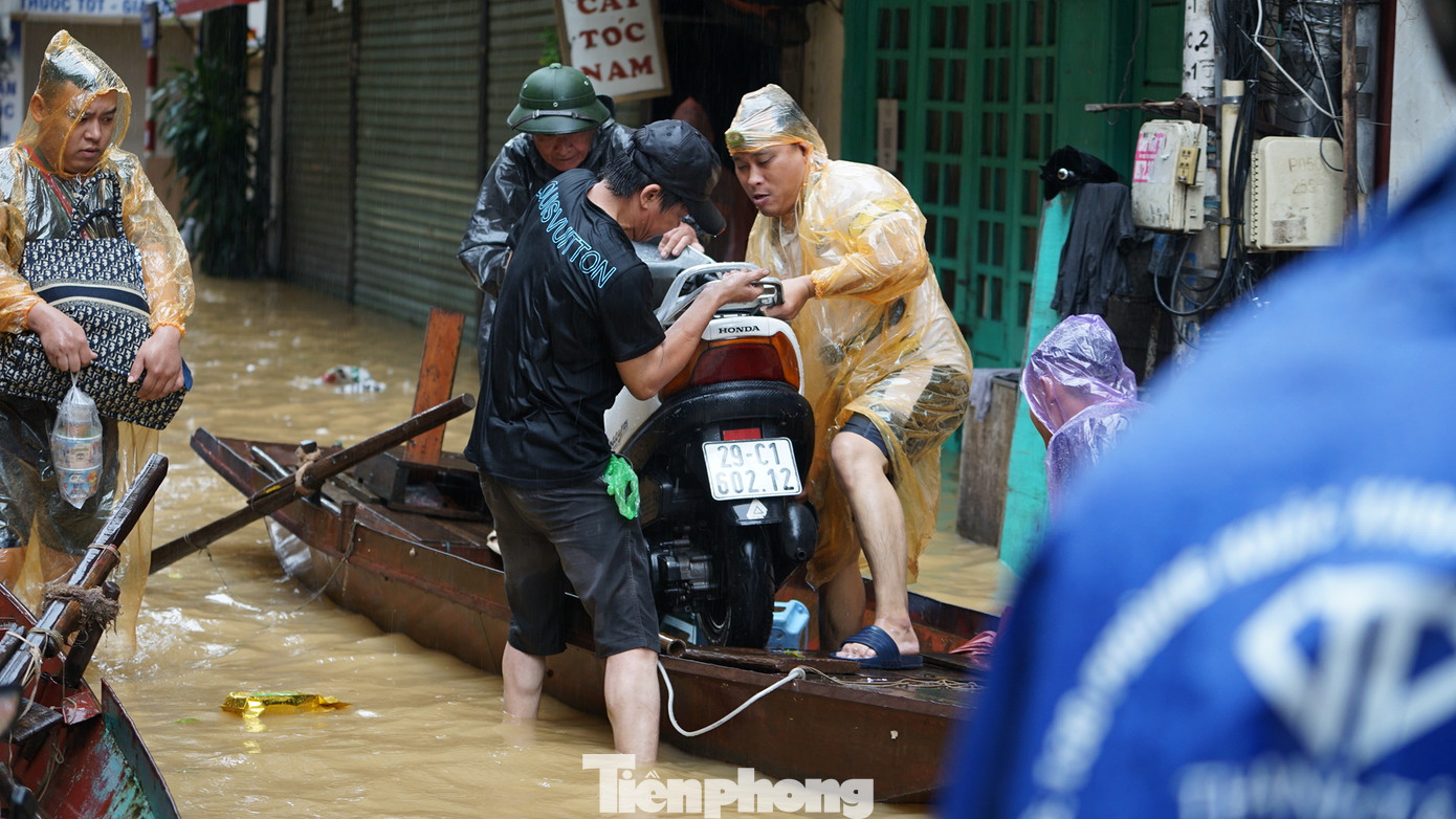 Tài sản có giá trị được người dân vận chuyển bằng thuyền ra khỏi khu vực ngập sâu.