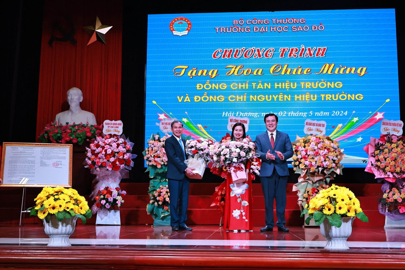 Thứ trưởng Bộ Công thương Nguyễn Sinh Nhật Tân tặng hoa chúc mừng Tân Hiệu trưởng Nguyễn Thị Kim Nguyên và Nguyên Hiệu trưởng Đinh Văn Nhượng.