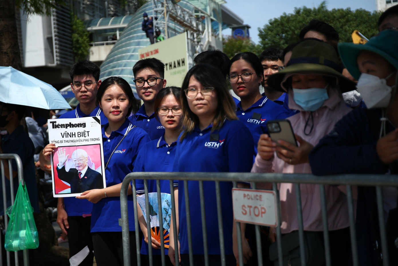 Sinh viên USTH tại một số điểm có đông người dân đứng chờ đoàn xe chở linh cữu Tổng Bí thư đi qua.