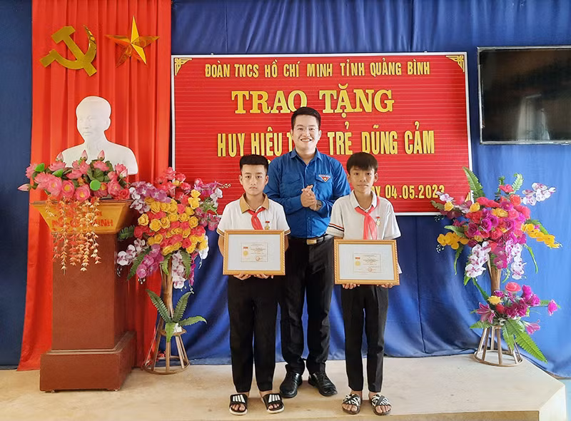 Đại diện Tỉnh Đoàn Quảng Bình trao Huy hiệu “Tuổi trẻ dũng cảm” của Ban Chấp hành Trung ương Đoàn TNCS Hồ Chí Minh cho hai học sinh có hành động dũng cảm cứu người lúc bị nạn