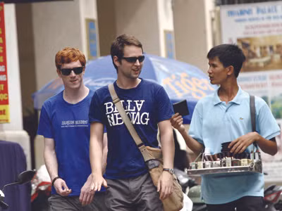 Khách du lịch quốc tế bị người bán dạo trên phố Hà Nội chèo kéo mua hàng. Anh: Ngọc Chân