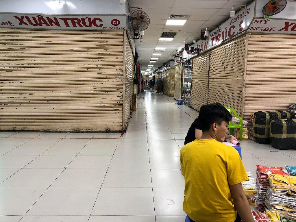 Tiểu thương ngồi tám chuyện hoặc lướt điện thoại vì vắng khách mua