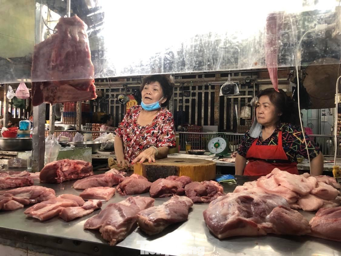 Bà Dương Mai (bìa trái) buồn tênh khi quá trưa nhưng thịt heo vẫn còn ê hề