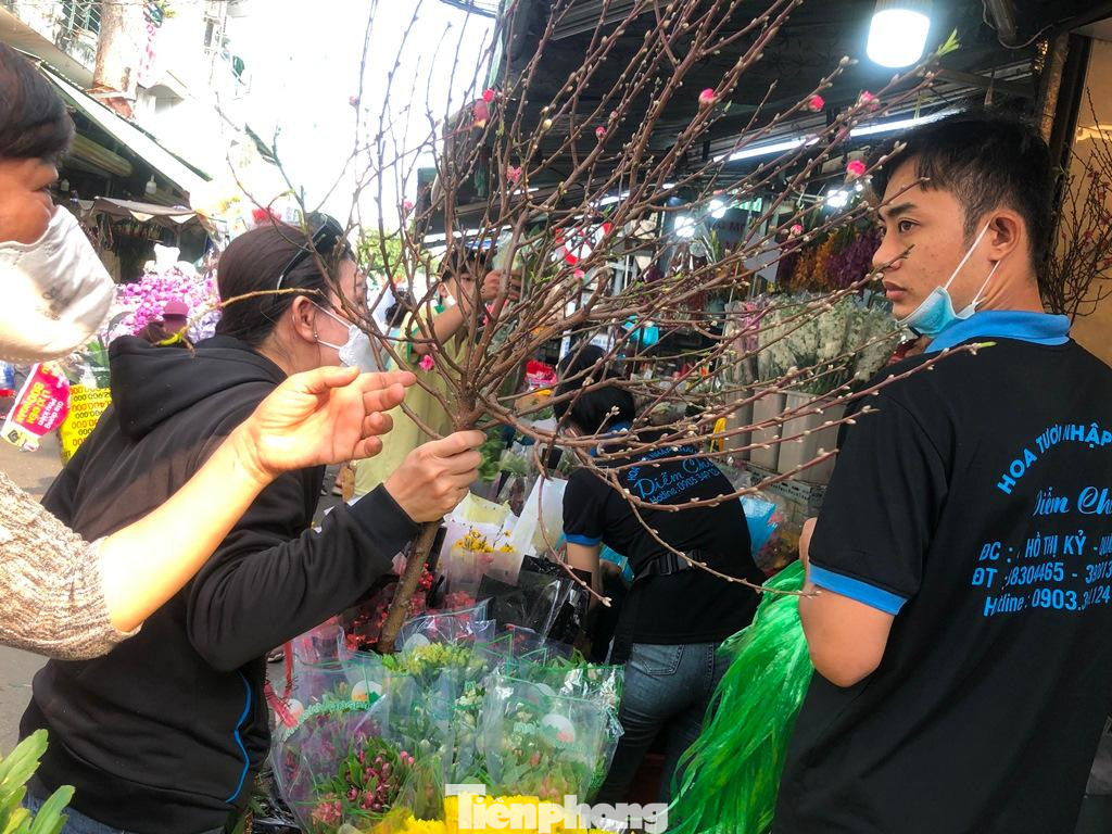 &quot;Cành đào đẹp quá, nhỏ gọn để cắm bình trang trí trong phòng, giá lại mềm nên dễ mua. Tôi còn dùng cành đào này làm quà Tết tặng bạn bè năm nay&quot; - chị Thanh Liên (ngụ quận Tân Bình) chia sẻ.