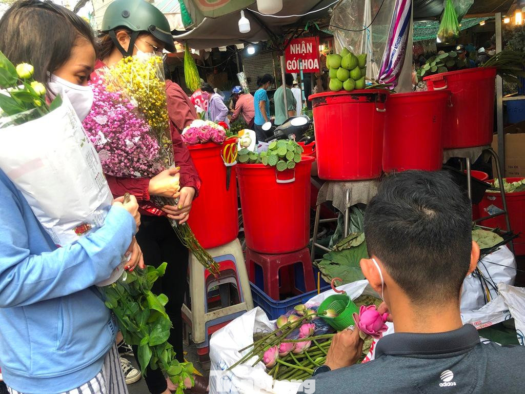 Các chị ôm hoa trĩu tay, các chị đều mua hoa số lượng lớn trong dịp này.