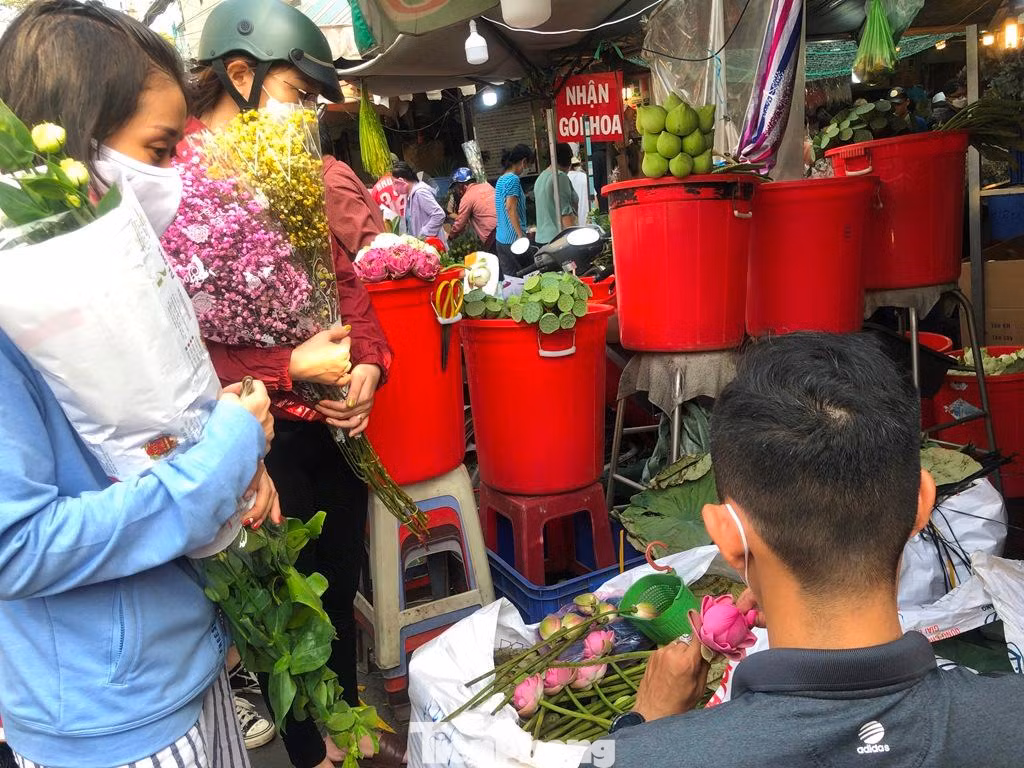 Các chị ôm hoa trĩu tay, các chị đều mua hoa số lượng lớn trong dịp này.