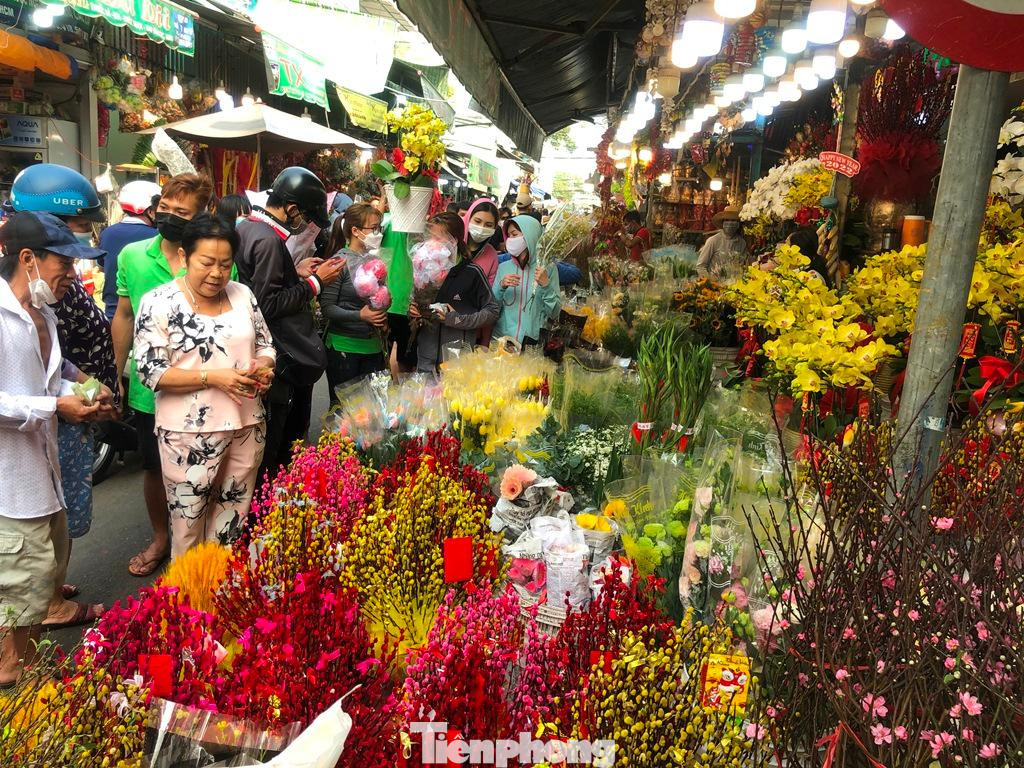 Các loại đông đào, thanh liễu, tuyết mai... rực rỡ màu sắc tại chợ hoa Tết. &quot;Nhiều hoa chỉ có một màu trắng hoặc vàng, người thợ thường nhuộm thêm màu xanh, đỏ, vàng, tím... cho đẹp để chơi Tết. Năm nay do dịch, hoa về chợ ít hơn tầm 30% so với Tết 2021, giá cả cũng tăng khoảng 20% nhưng sức mua không cao&quot; - chị Liễu, chủ sạp hoa Minh Liễu (quận 3) nói.