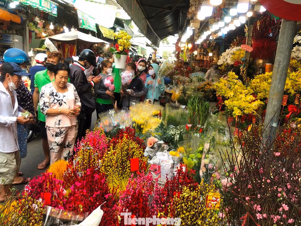 Các loại đông đào, thanh liễu, tuyết mai... rực rỡ màu sắc tại chợ hoa Tết. "Nhiều hoa chỉ có một màu trắng hoặc vàng, người thợ thường nhuộm thêm màu xanh, đỏ, vàng, tím... cho đẹp để chơi Tết. Năm nay do dịch, hoa về chợ ít hơn tầm 30% so với Tết 2021, giá cả cũng tăng khoảng 20% nhưng sức mua không cao" - chị Liễu, chủ sạp hoa Minh Liễu (quận 3) nói.