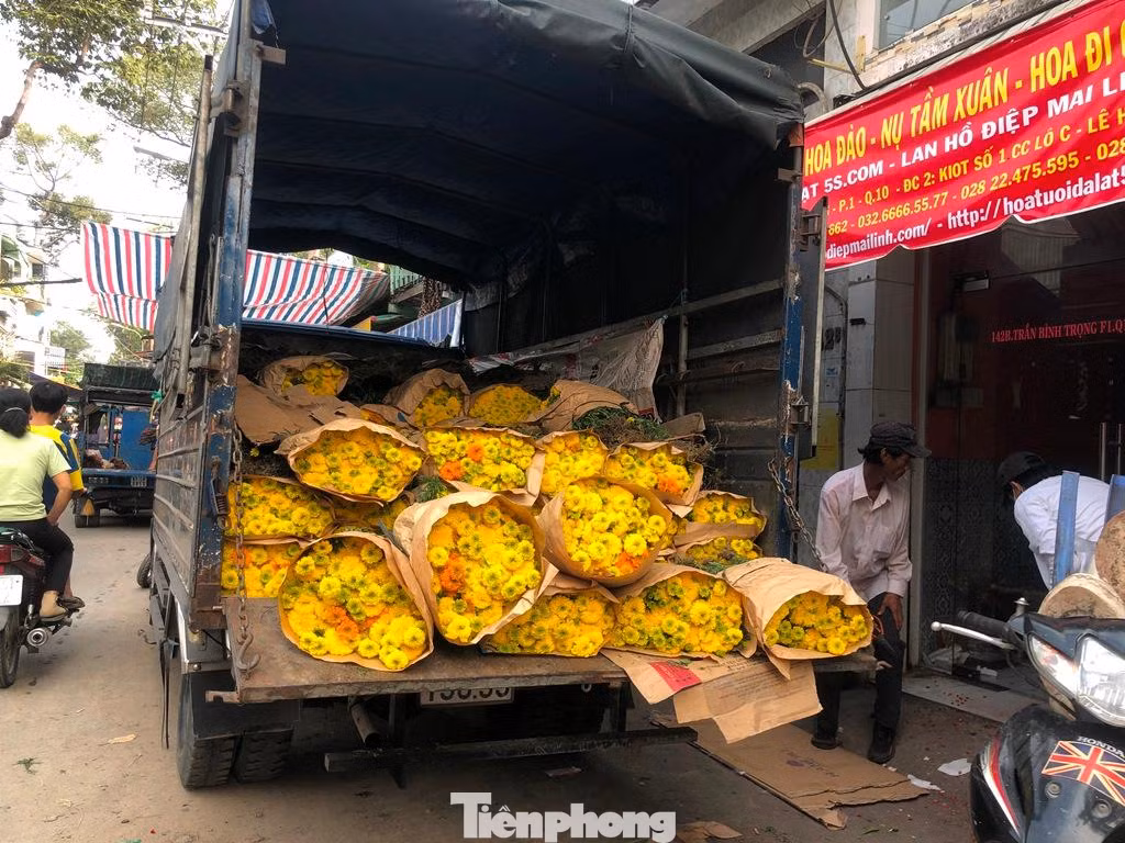 Một xe tải nhỏ chuẩn bị xuống hoa cho sạp.
