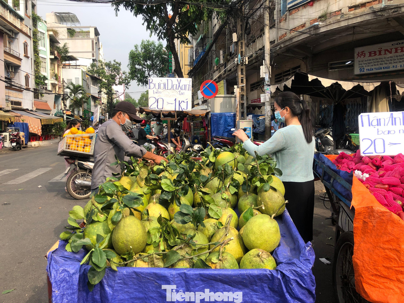 Bưởi da xanh nguyên cành lá mới hái giá chỉ 20.000 đồng/kg. &quot;Bình thường bưởi trái to, có cành thế này có giá từ 75.000 - 100.000 đồng/kg nhưng nay bưởi rớt giá sâu, từ sáng đến giờ tôi bán chưa được bao nhiêu cả. Rất vắng!&quot; - anh Châu, bán bưởi dạo lo lắng nói.