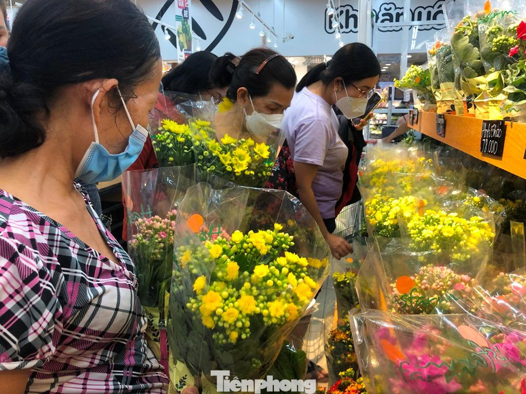 Ngoài thực phẩm, quầy hàng hoa cũng nhộn nhịp khách. Đa số đều là hoa từ Đà Lạt như sống đời, hồng, vạn tuế... có giá hạt dẻ, từ 45.000-155.000 đồng/chậu tùy loại. Khách đều mua 3-4 chậu về chưng Tết.