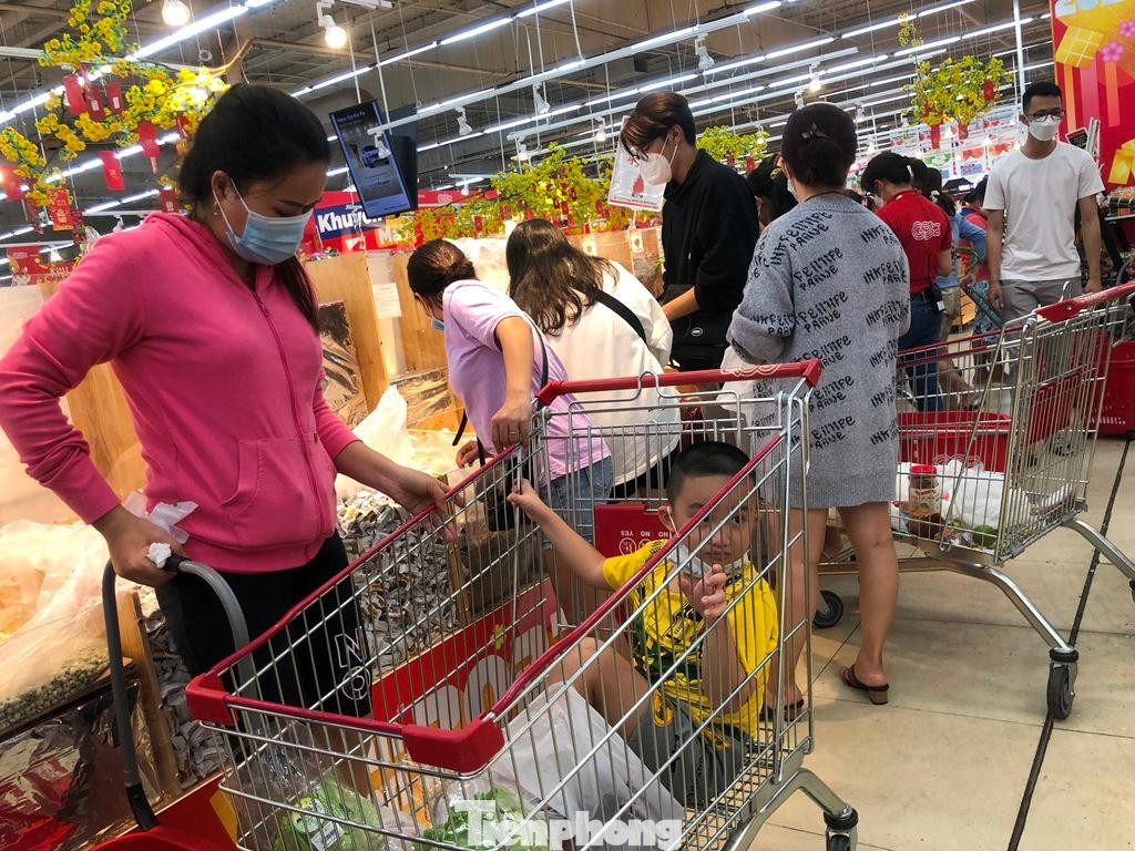 Do khách quá đông, trẻ em được phụ huynh cho vào xe đẩy hàng để khỏi bị lạc.